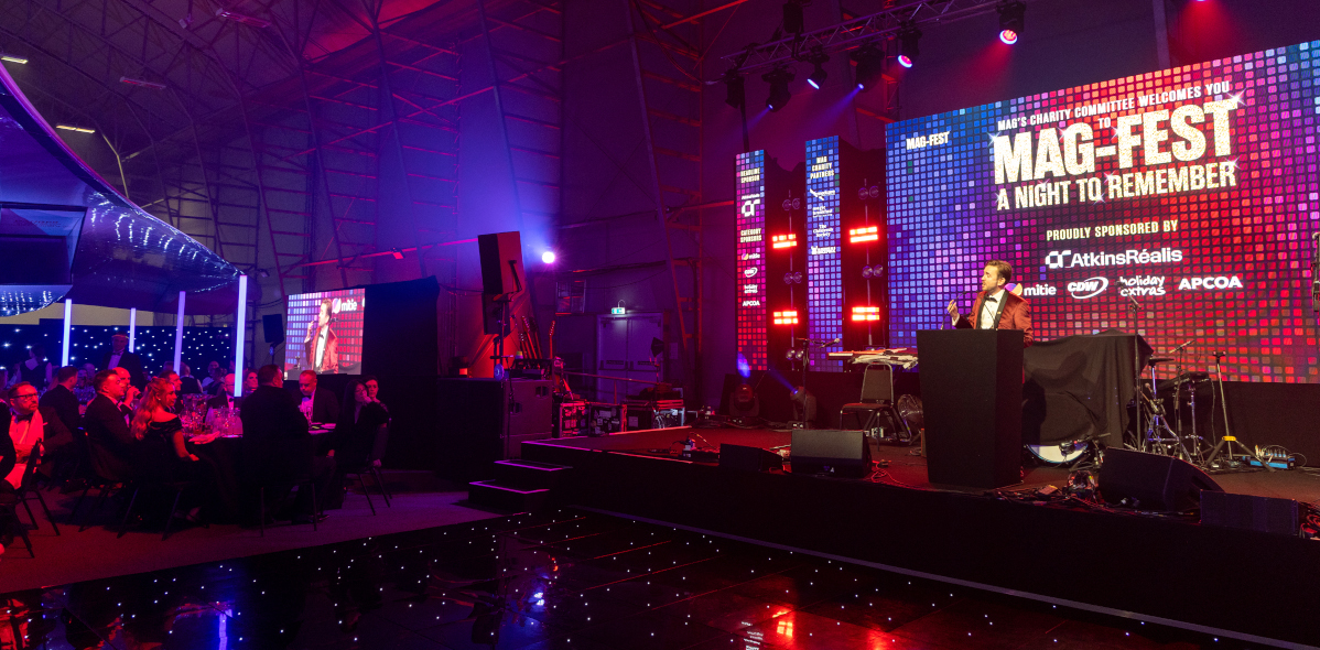 Kevin Durham on stage hosting a large-scale corporate event