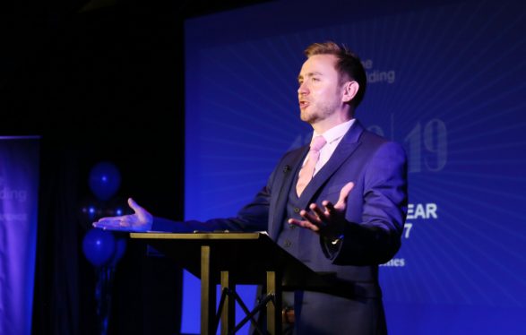 Kevin Durham hosting on stage, microphone in hand