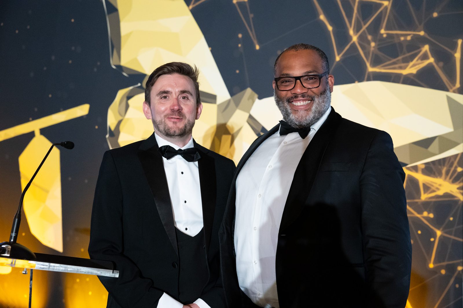 Kevin Durham in black tie hosting the Digital Transformation Awards with a guest presenter